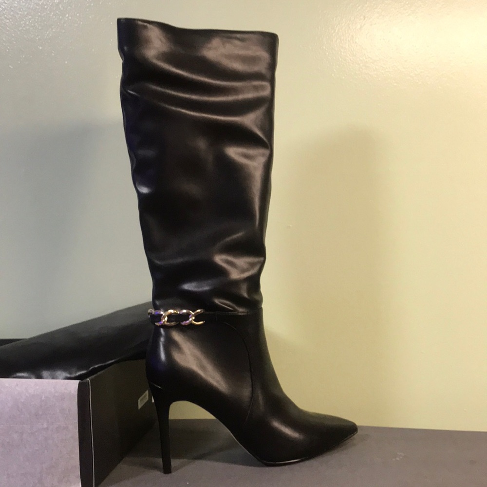 Saks Fifth Avenue. Black, tall leather boots. Past the calf, hit knee cap